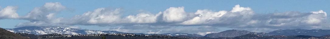 Clouds layer over snow covered mountains in San Diego's Peninsular Ranges. banner