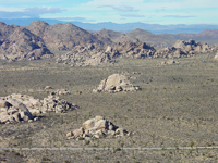 Boulder piles rise above a pediment surface in Joshua Tree National Park. 