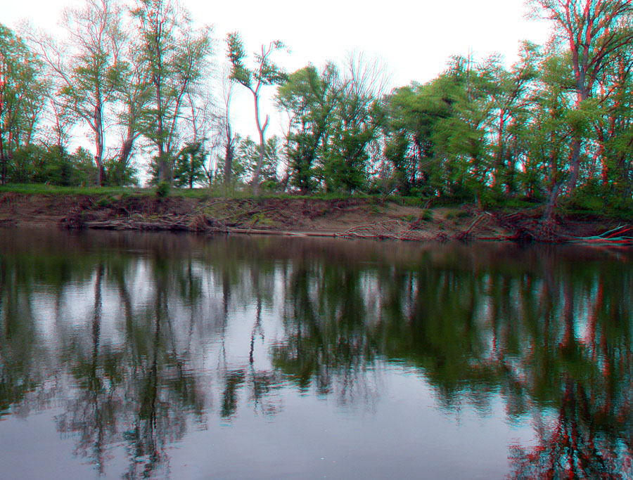 View of the opposite shore of the Scioto River in the vicinity of Hopeton Earthworks. Reflection of trees on the still river water.