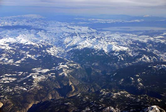 Airliner view of the Sierra Nevada Range over Yosemite National Park with Yosemite Valley, Snow-caped peaks, and Mono Lake in the distance.