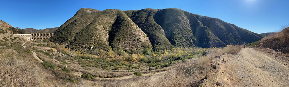 A panoramic view of the high mountainside on the south side of Del Dios Gorge showing almost a dozen ravines draining into the river bed, with Lake Hodges Dam on the Left and the Del Dios Trail on the right.