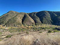 View of the high mountainside on the south side of Del Dios Gorge showing several ravines draining into the river bed.