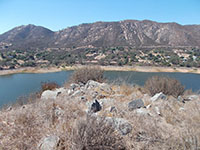 View from near the flagpole on the peninsula in Lake Hodges, looking north across the lake towda the mountain front of the Del Dios Highlands. Oak forests dominate the lower slopes in the community of Del Dios. Rocky slopes and chaparral dominate the upper slopes.