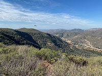 View looking down into San Elijo Gorge in the vicinity of the Elfin Forest parking area along Harmony Grove Roadk. The Way Up Trail is visible on the chaparral covered mountainside.
