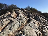View looking up at a large outcrop of greenstone on Double Peak shat shows pillow-like structures