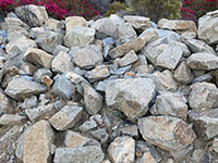 A pile of large angular-shaped granitice boulders that is used as landscaping on CSUSM campus. 
