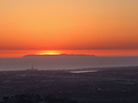 Zoomed-in view of the sun setting over San Clemente Islad as seen from San Marcos Peak.