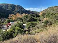 View of the Elfin Forest Interpretive Center in the forested area in San Elijo Canyon as seen from near the park entrance sign.