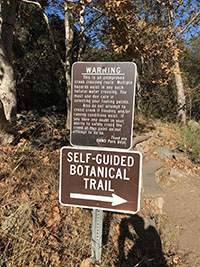 Creek crossing warning sign near the rocky creek bed of Escondido Creek.