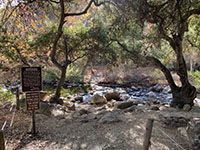 A rocky creek crossing and a warning sign along Escondido Creek.
