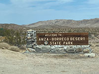View looking north at the Anza Borrego Desert State Park sign with northern Coyote Mountains in distance.