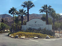 Glen Ivy Hotspring (Resort) entrance sign, with palm trees and Santa Ana Mountains in distance.