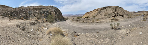 Panoramic view of looking south along the unpaved access road toward the mouth of Ocotillo Canyon. Igneous gneiss and schist is on the left and flat to steeply dipping Pliocene sedimentary rocks are on the right side of the canyon.