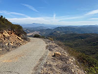 Mt. Whitney Peak access road to radio tower with view of mountains near Lake Hodges in the distance.