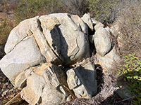 Granitic boulder outcrop cut diagonally by an aplite dike