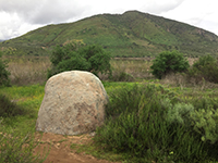 Granite boulder along the Bernardo Bay Trail with Bernardo Mountain in the distance. 