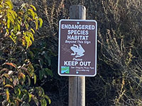 Endangered Species habitat sign with a frog symbol and keep out warning.