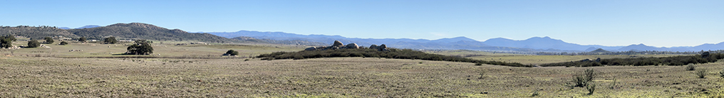 Panoramic view looking east of the plains of the Ramona Grasslands Preserve with the high peaks and ridgelines of the Peninsular Ranges in the distance.