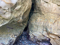 A small fault associated with a narrow sea cave entrance to a headland.
