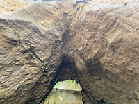 Small fault and fractures in sandstone  exposed in roof of the mouth of sealed sea cave.