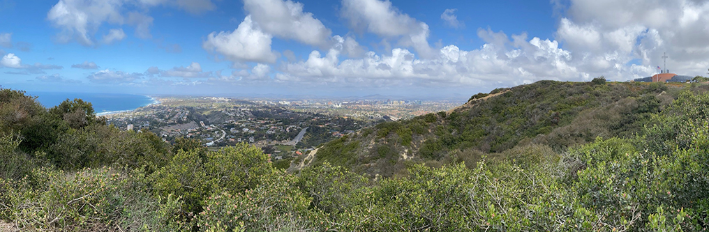 Panoramic view looking across the canyon where the Mount Soledad fault line ascends the north flank of the mountain and crosses the Mount Soledad National Veterans Memorial access road. The memorial is at the summit on the right.