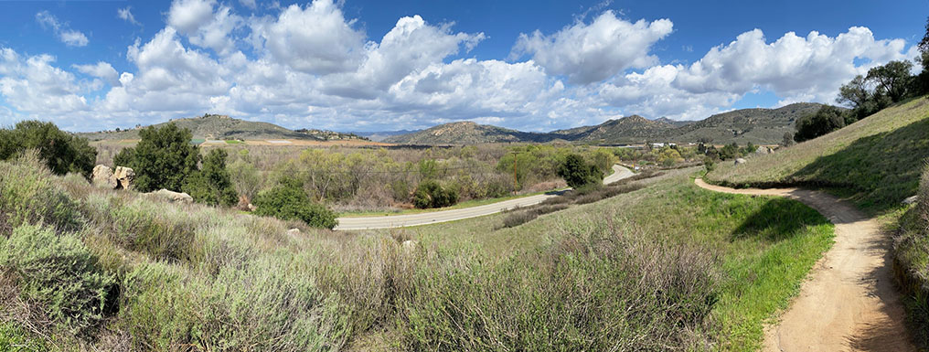 Panoramic view of hills surrounding San Pasqual Valley with Highland Valley Road and the Highland Valley Trail crossing a grassy slope.