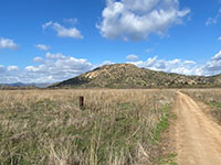 View southeast along trail across grasslands to distant Raptor Ridge.