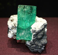 Green emerald crystal in white matrix.
