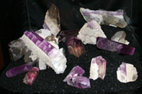 Purple tourmaline crystals in white matrix in display case.