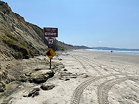 View looking south near the sign marking the north end of Torrey Pines State Beach. 