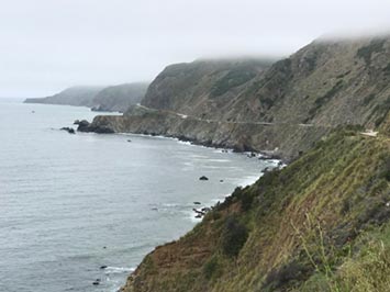 A fog (stratus layer) hugging the mountainsides along the Big Sur in California.