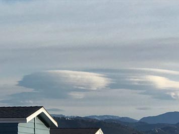 Zoomed in view of altocumulus lenticularis (lenticular orographic clouds) over high peaks near Julian, California