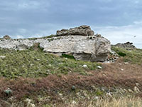 An ash deposit exposed in a white cliff north of the road, 1 mile west of the Visitor Center.