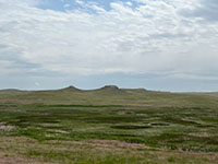 View looking south from the park road showing the short-grass prairie and wetlands of the Niobrara River Valley, with hills of the Miocene fossil-bearing strata in the distance. 