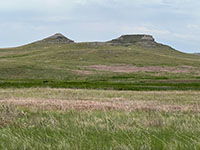 View looking north from the Visitor Center across the Niobrara River valley to two buttes, University Hill and Carnegie Hill where fossils were mined and collected. A trail from the visitor center leads to the quarries on the side of the hills.