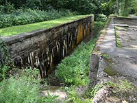 View of an old river lock with cement walls about 12 high.