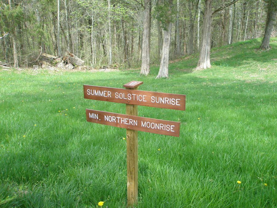 Arrow on sign indicating the direction of the summersolstice sunrixe and minimum northern moonrise.