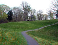 View of large sinuous bends of the Great Serpent Mound along a park trail.