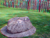 A glacial erratic (boulder) is used to hold a historic marker.