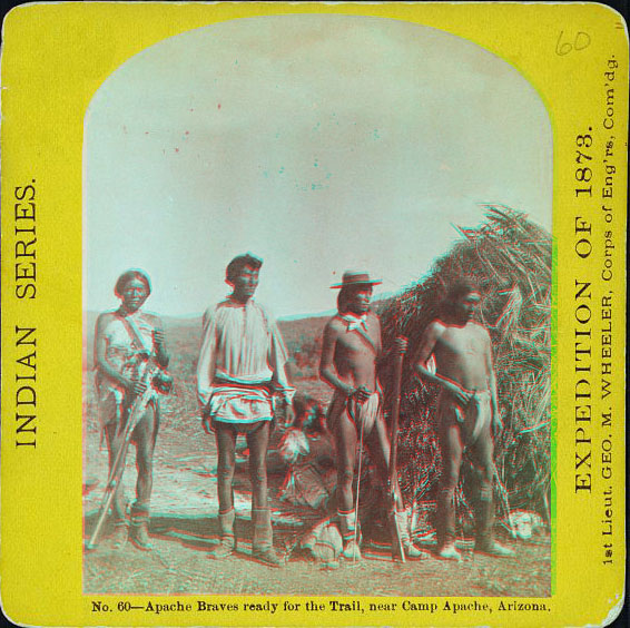 four men in native dress, three with rifles.