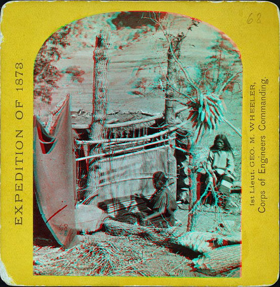 Two women sitting near a weaving setup outside