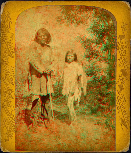 A man and child in native dress, standing outside