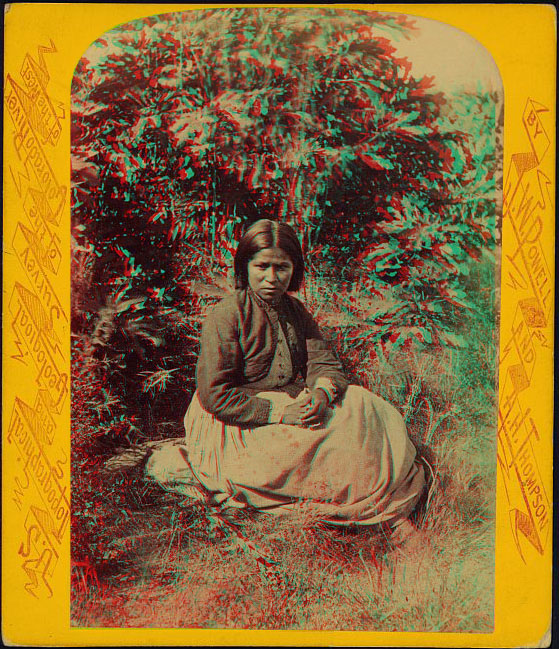 A soman sitting, surrounded by plants 