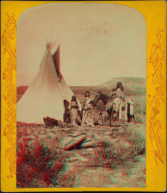 A family group standing outside of a teepee. A woman and a child are sitting on a horse. Two bundles are on the ground near the camera location