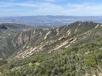 Steeply dipping sedimentary rock formations (Tertiary age) overlook area on Piuma Road.