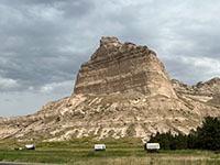 Wagon train on display on the Oregon Trail through Mitchell Pass with Eagle Rock bluff near the Visitor Center.