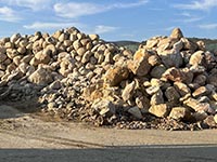 Large and intermediate sided boulders used in construction, particularly in yard displays and stone walls.